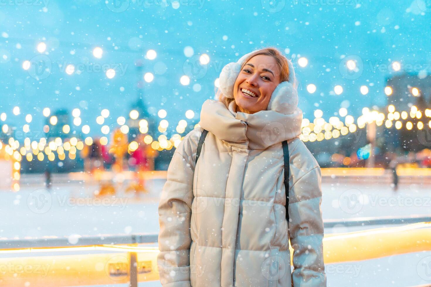 inverno. Natal feriado noite, mulher em pé lado de fora e sorriso. Natal iluminação e decoração fundo. inverno feriado temporada. foto