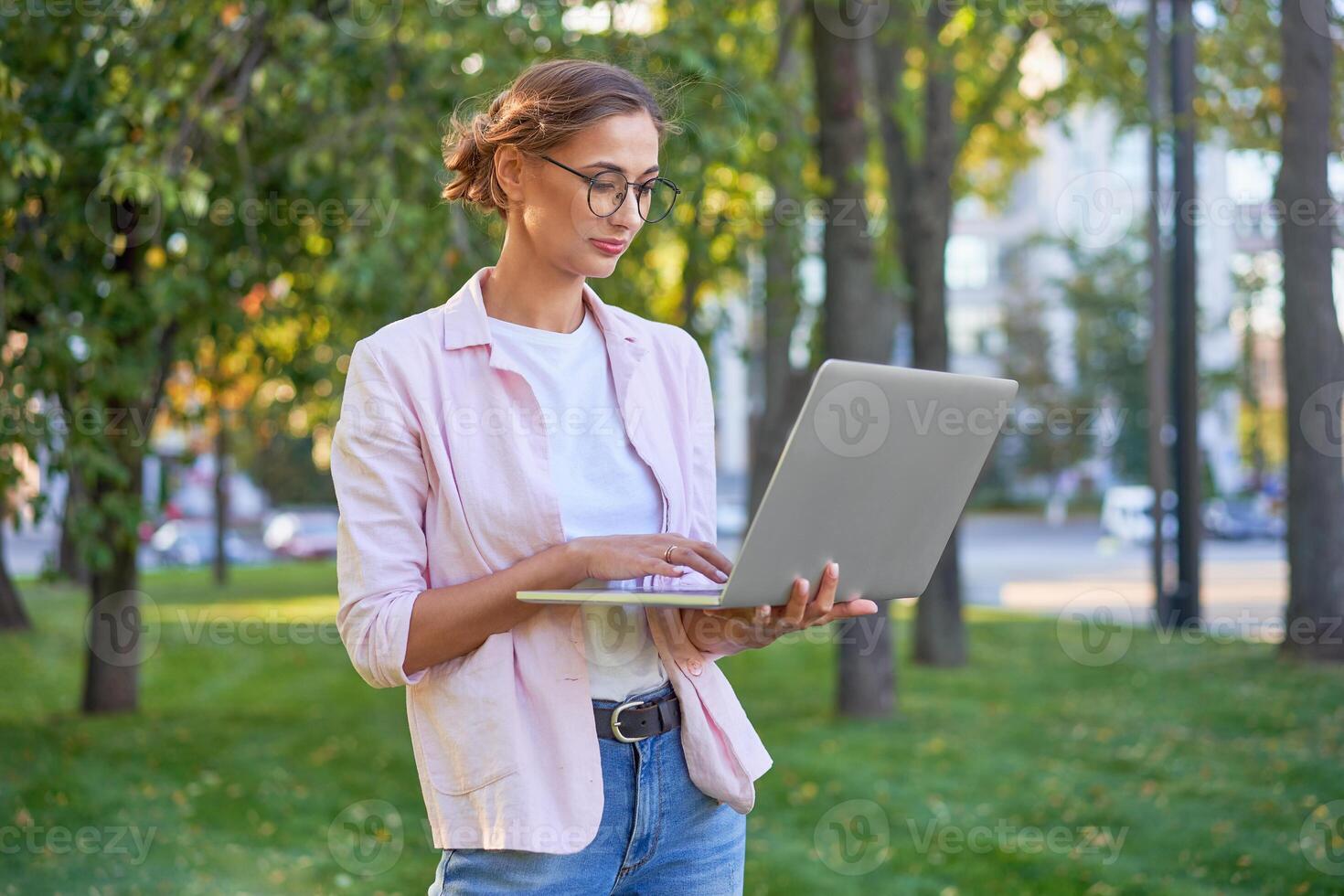 empresária em pé verão parque usando computador portátil o negócio persone trabalhando controlo remoto. ao ar livre foto