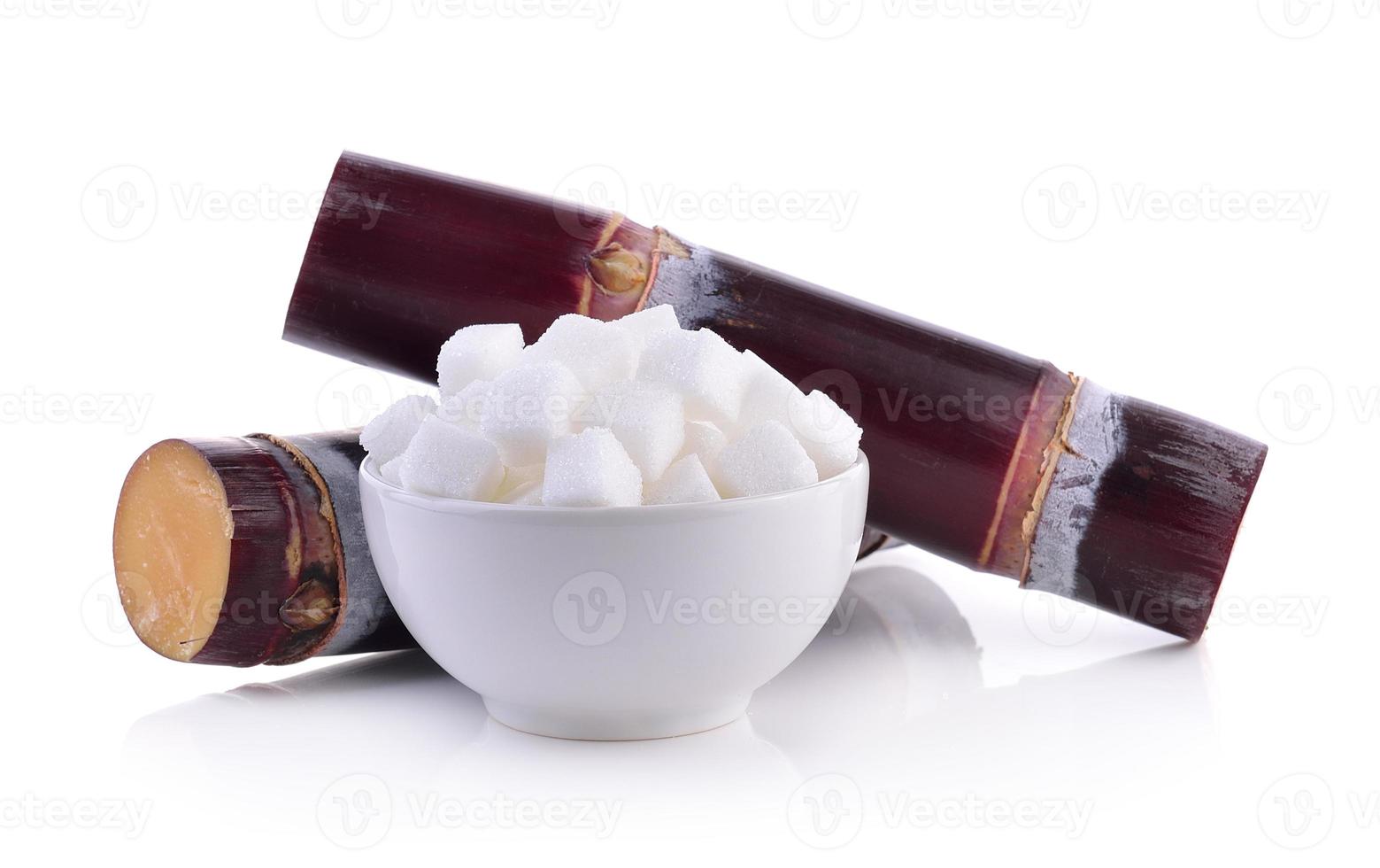 cana-de-açúcar e cubo de açúcar no fundo branco foto