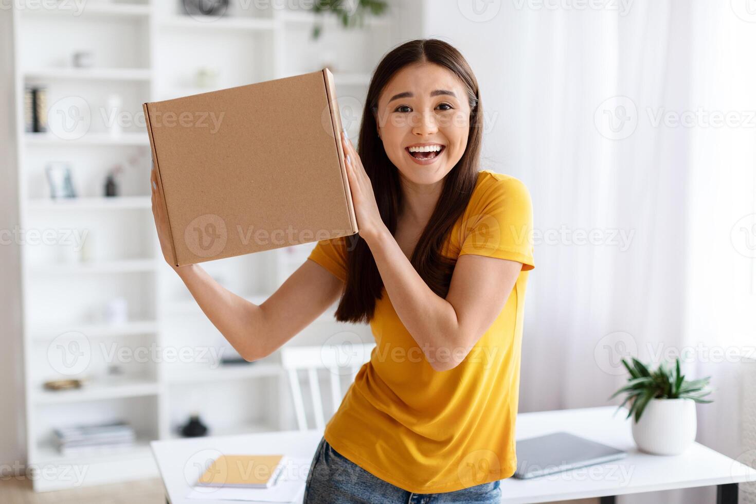 em êxtase ásia mulher segurando acima cartão caixa com alegre expressão foto