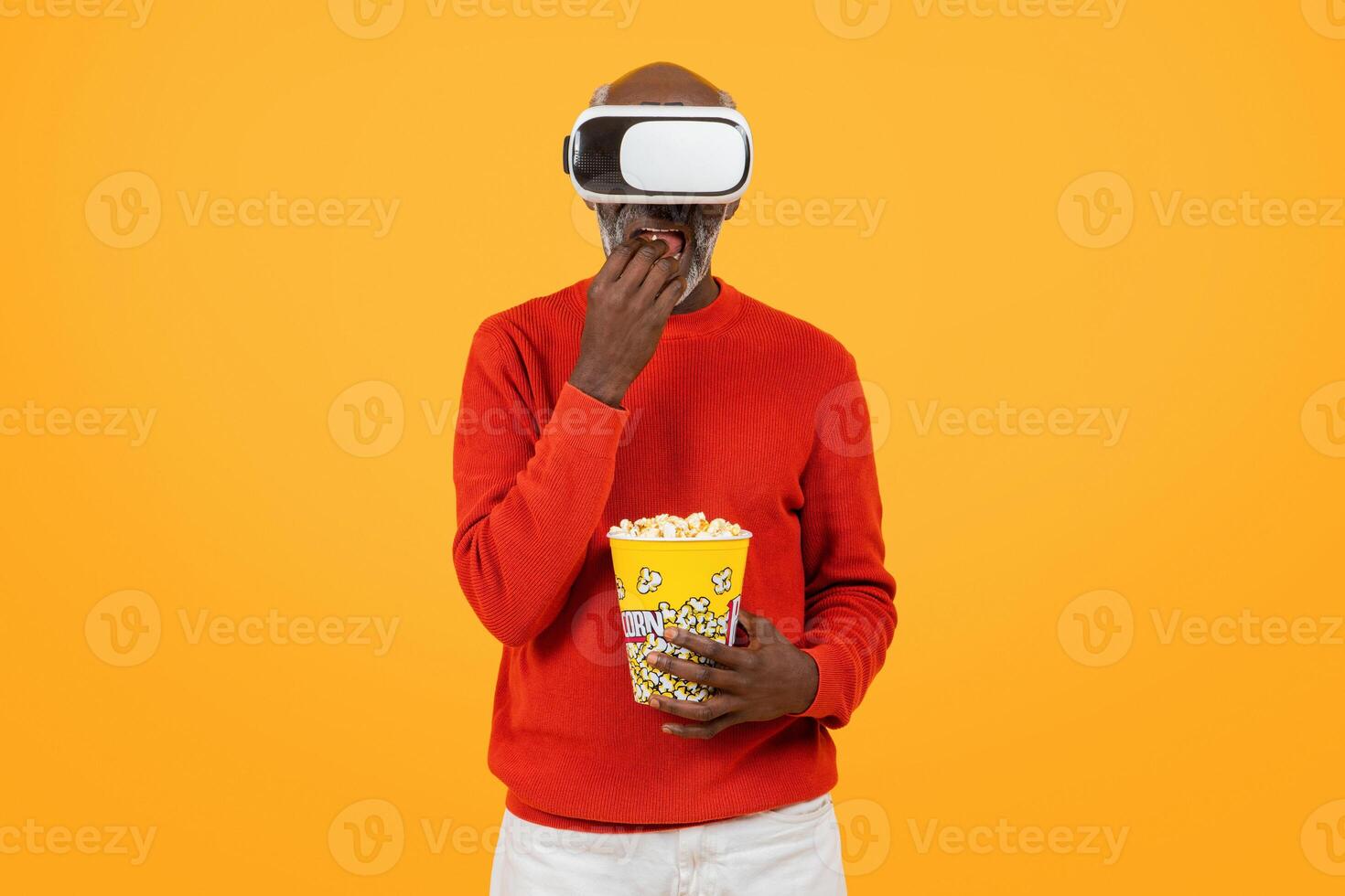 absorta Senior Preto homem dentro uma vermelho suéter desfrutando virtual realidade com uma fone de ouvido foto