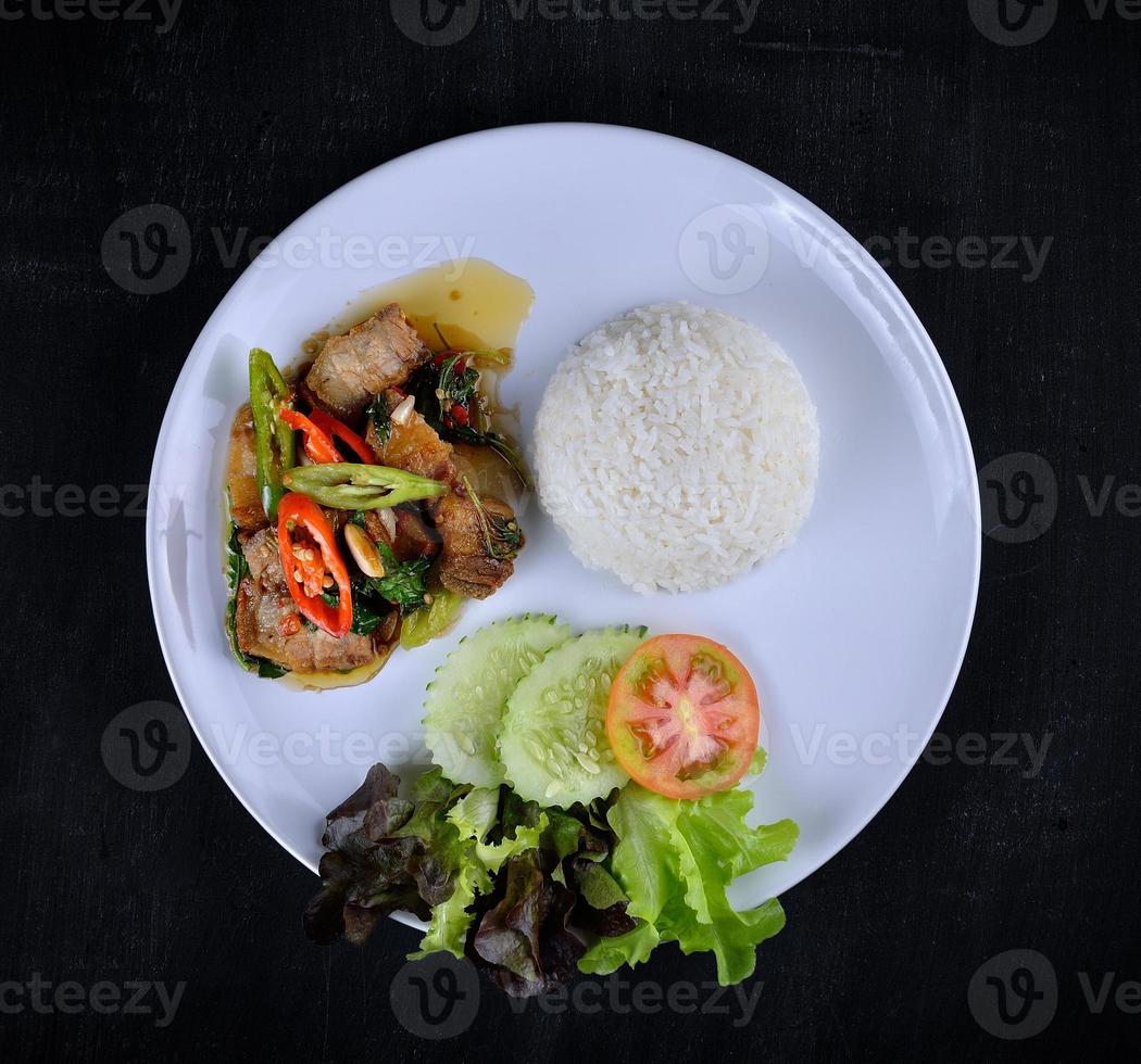 arroz coberto com carne de porco frita e manjericão foto
