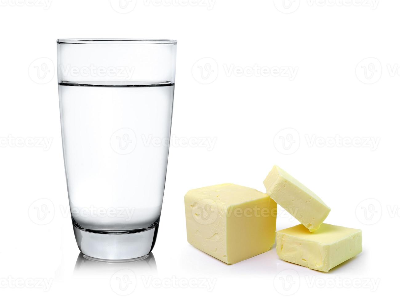 manteiga fresca e copo de água isolado no fundo branco foto
