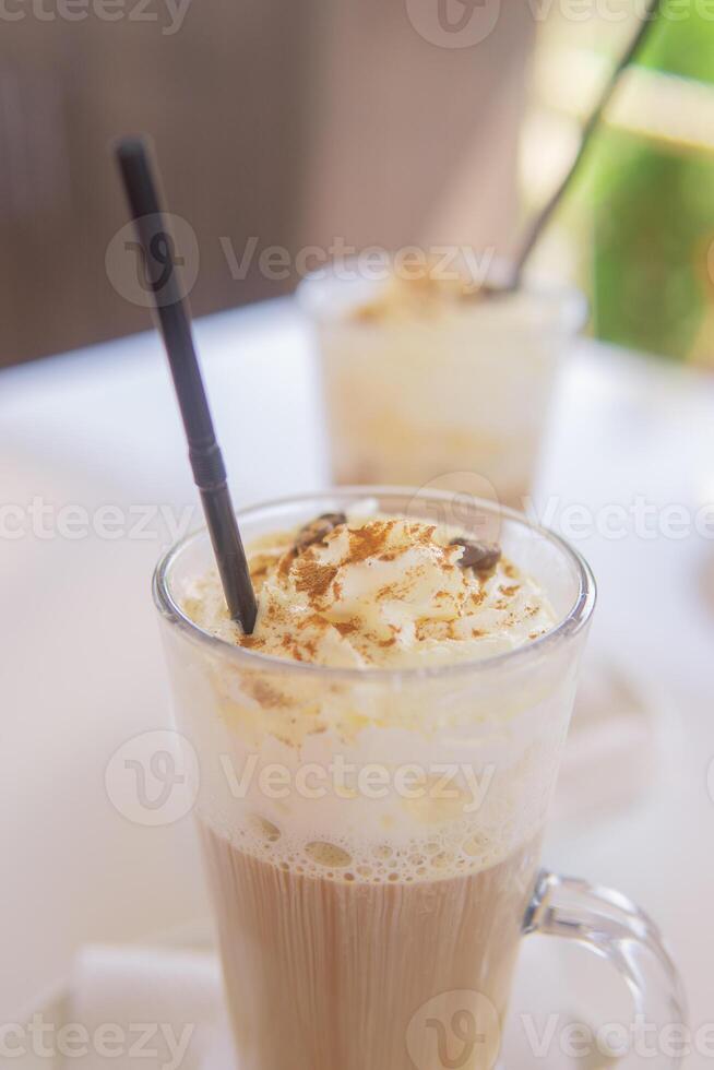 café é servido dentro uma alta vidro vidro com uma canudo. a conceito do café bebidas a partir de a Barra cardápio foto