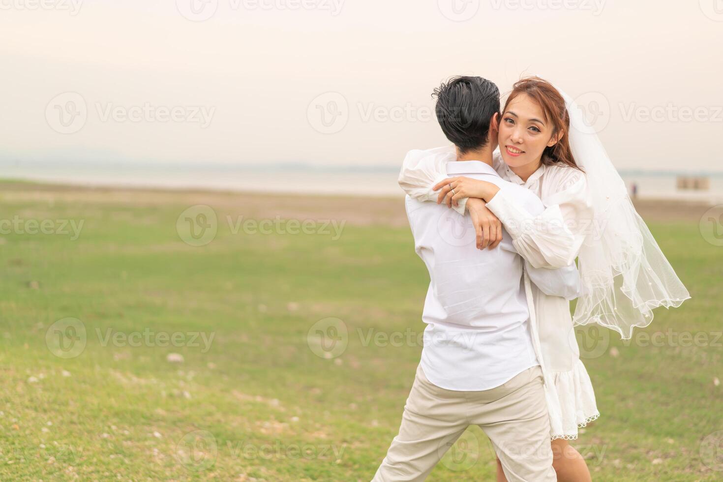 feliz jovem casal asiático em roupas de noivos foto