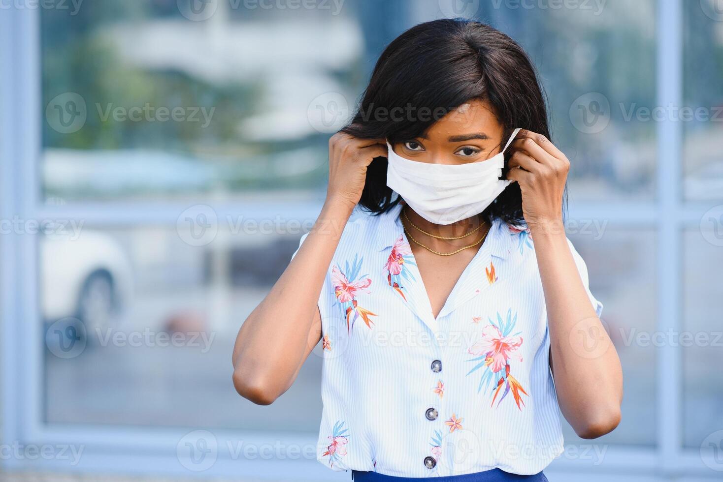 jovem voluntária afro-americana usando máscara facial ao ar livre. quarentena de coronavírus e pandemia global. foto