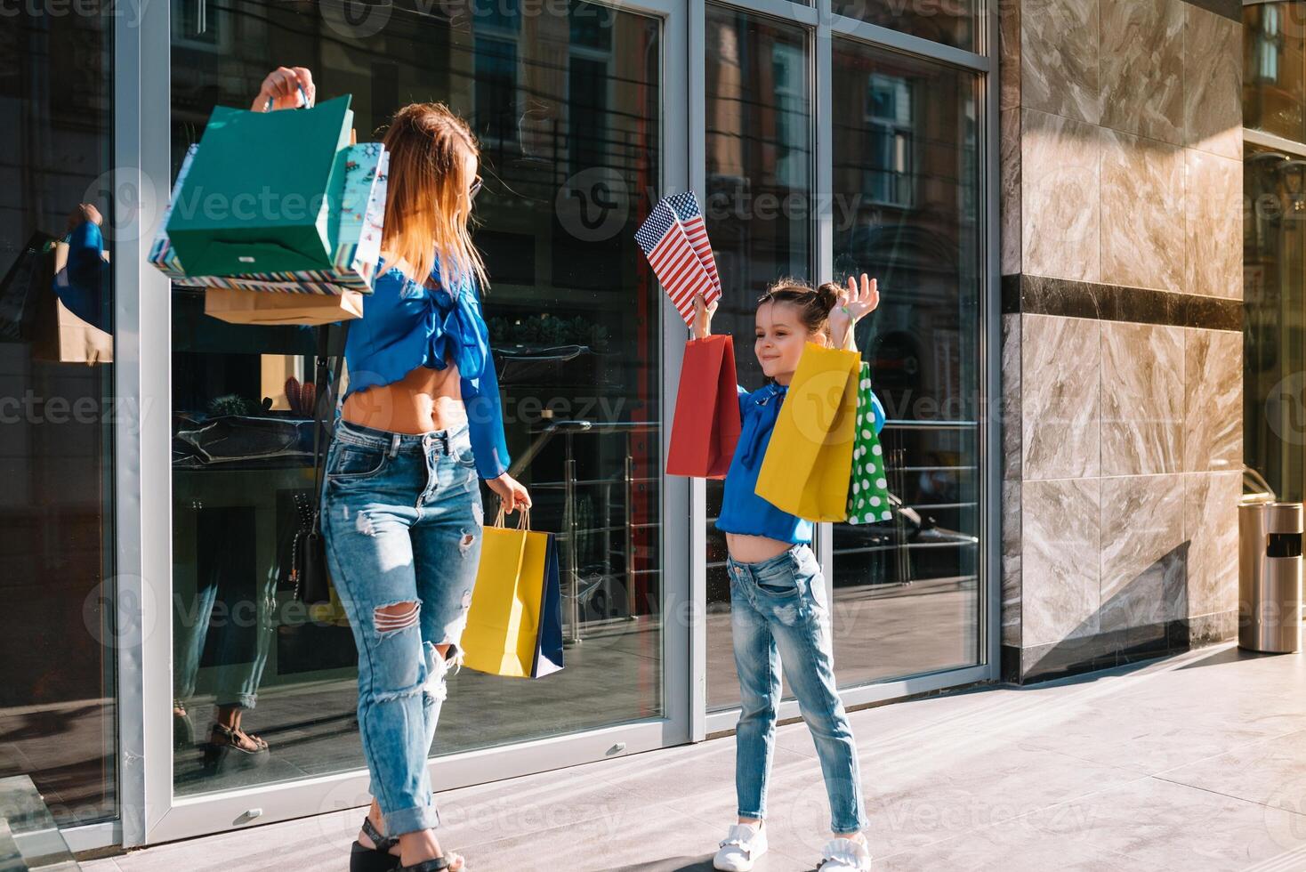 oferta, consumismo e pessoas conceito - feliz jovem mulheres dela Dauther com compras bolsas caminhando cidade rua. foto