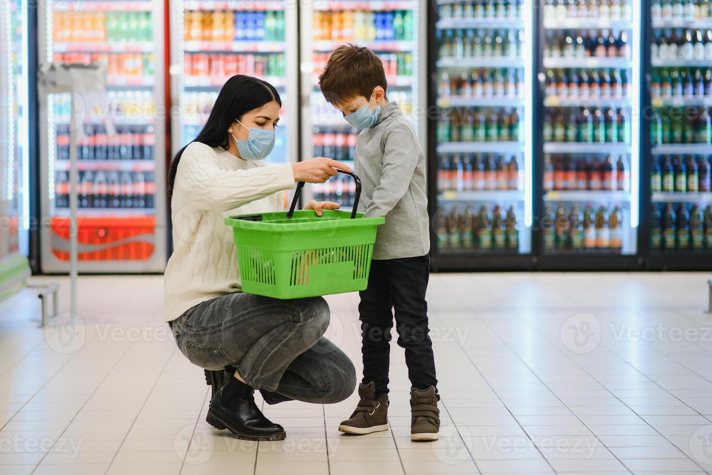 retrato do uma mãe e dela pequeno filho vestindo protetora face mascarar às uma supermercado durante a coronavírus epidemia ou gripe surto. esvaziar espaço para texto foto