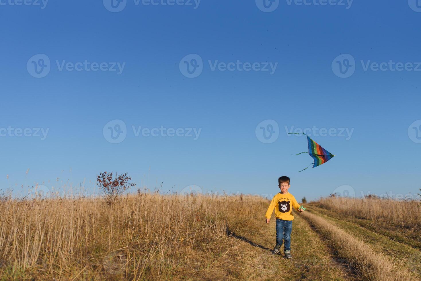 pequeno Garoto jogando com pipa em Prado. infância conceito foto