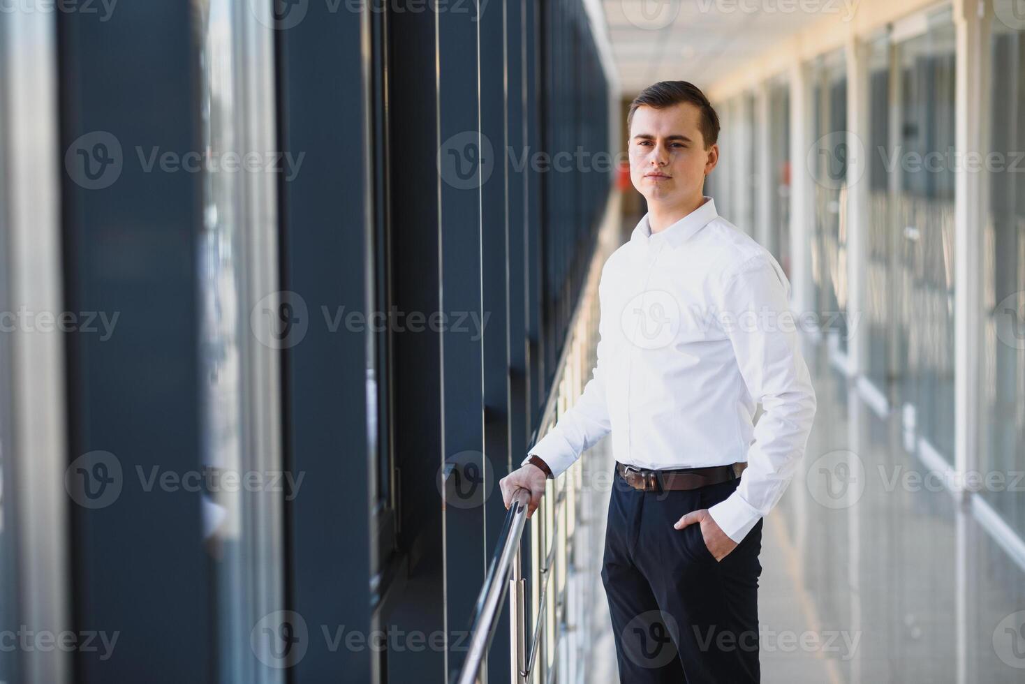 bonito jovem homem de negocios perto janela dentro escritório foto