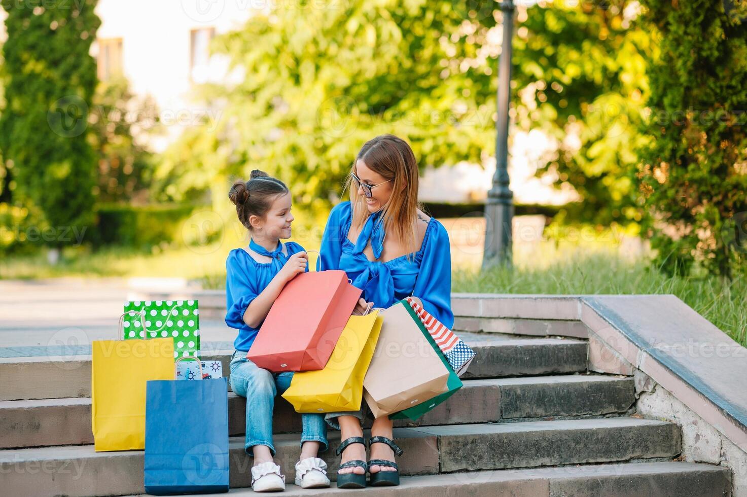 oferta, consumismo e pessoas conceito - feliz jovem mulheres dela Dauther com compras bolsas caminhando cidade rua foto