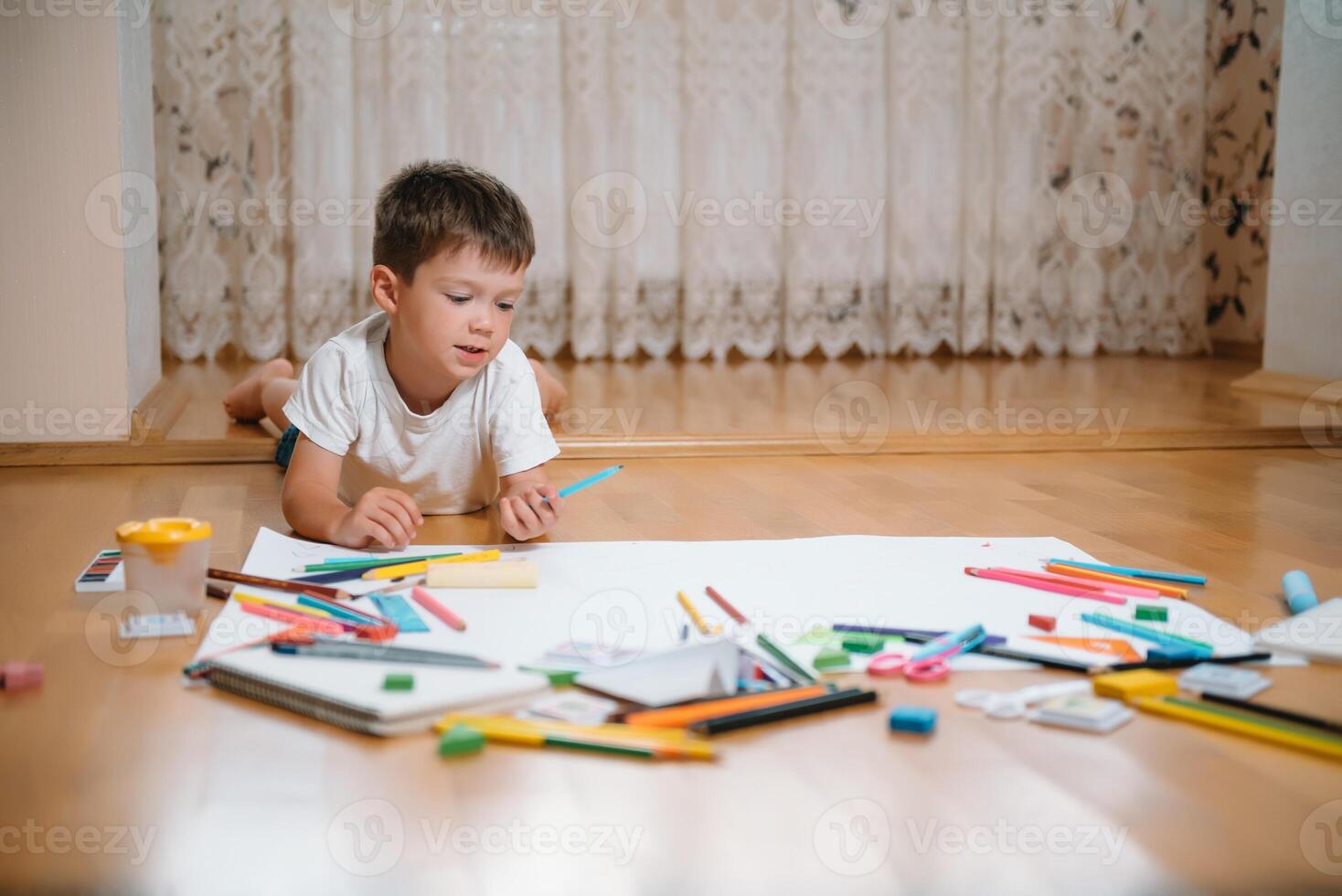 crianças desenhando em chão em papel. pré escola Garoto e menina jogar em chão com educacional brinquedos - blocos, trem, Ferrovia, avião. brinquedos para pré escola e Jardim da infância. crianças às casa ou creche. foto