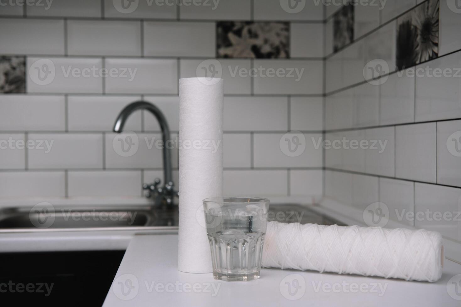 água filtros. carbono cartuchos e uma vidro em uma branco cozinha fundo. família filtração sistema. foto