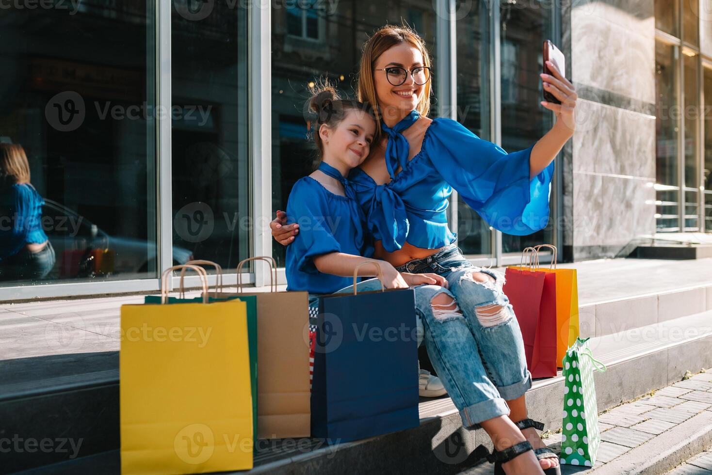 oferta, consumismo e pessoas conceito - feliz jovem mulheres dela Dauther com compras bolsas caminhando cidade rua foto