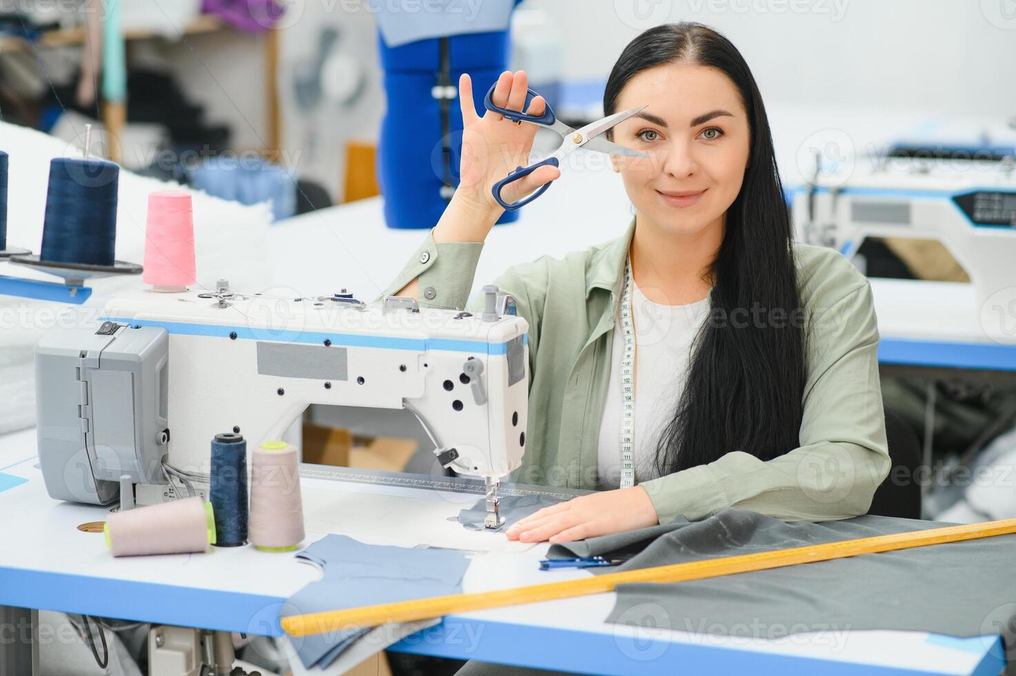 retrato do uma lindo costureira carregando uma fita a medida e trabalhando dentro uma têxtil fábrica foto