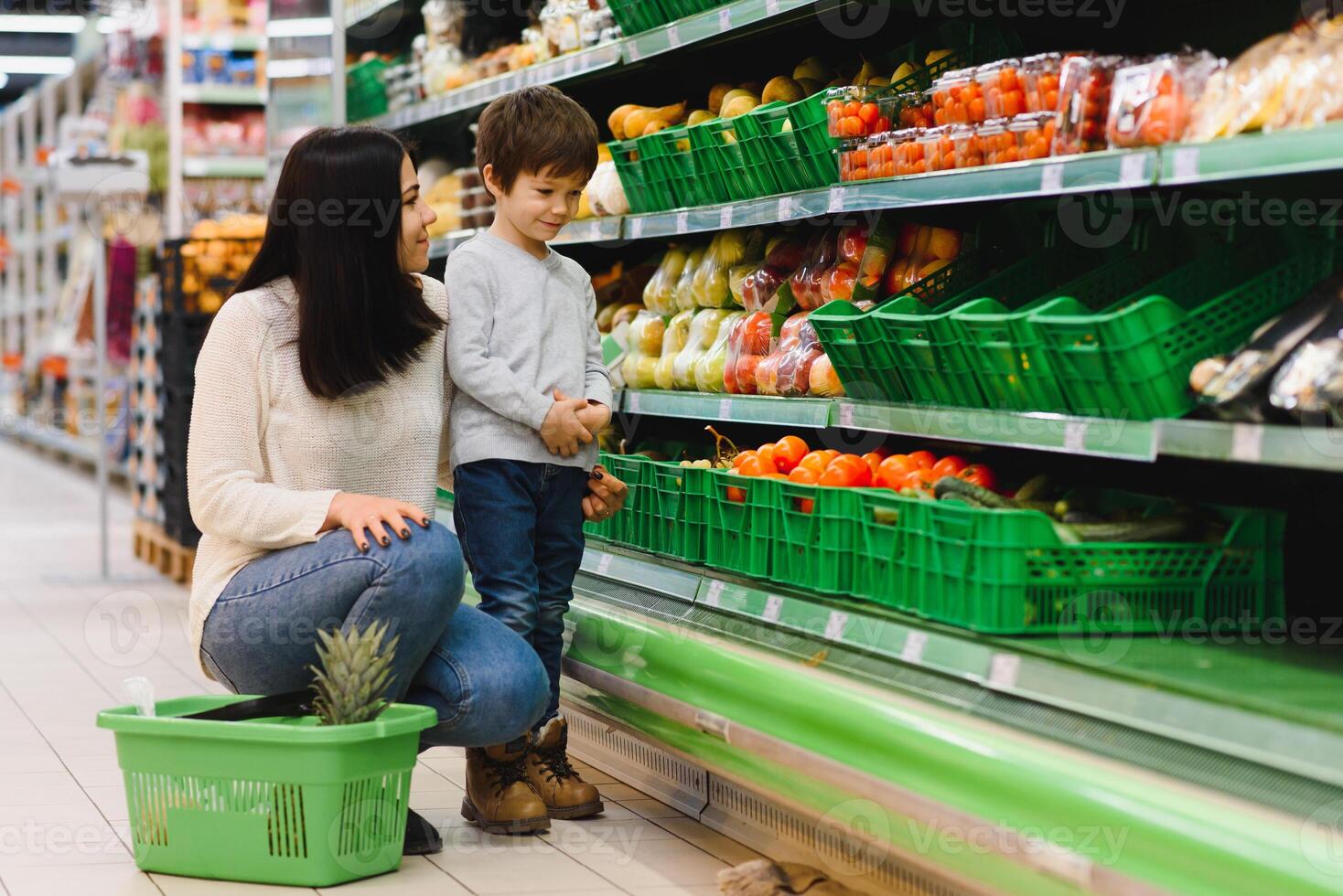 mulher e criança Garoto durante família compras com carrinho às supermercado foto