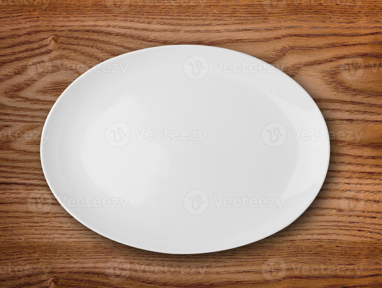 prato branco vazio na mesa de madeira foto