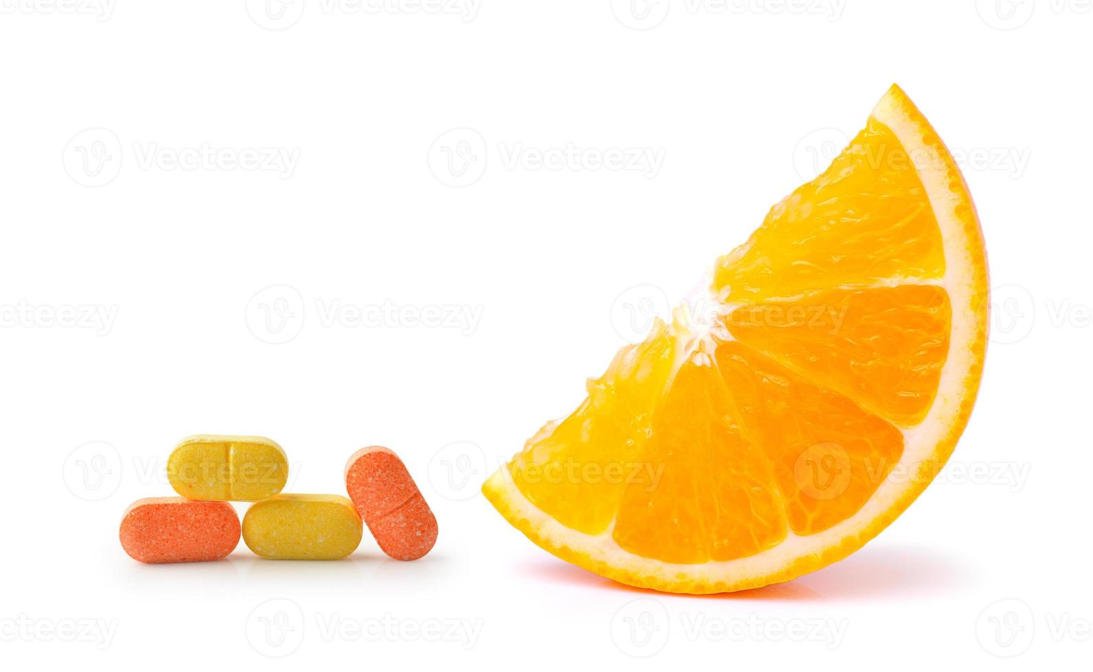 fruta laranja com comprimido de vitamina c em fundo branco foto