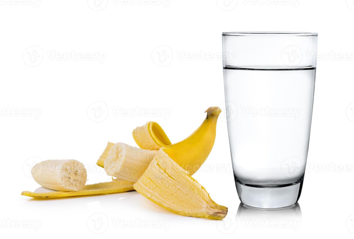 copo de água e banana isolado no fundo branco foto