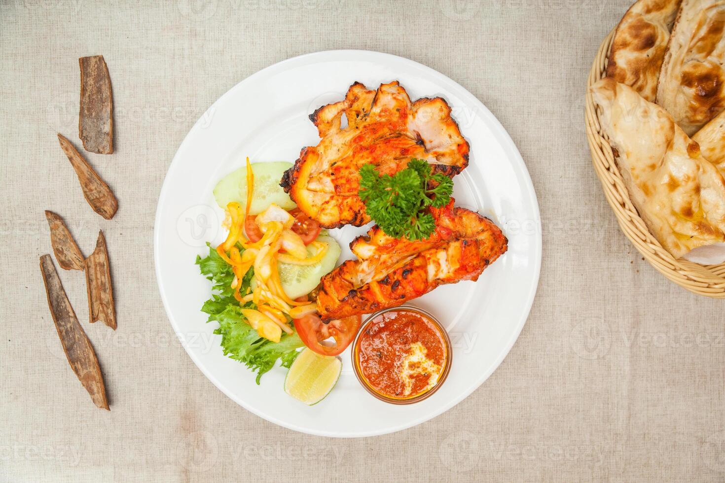 frango tandoori com salada e roti, chapati servido dentro uma prato isolado em mesa topo Visão do indiano especiarias Comida foto