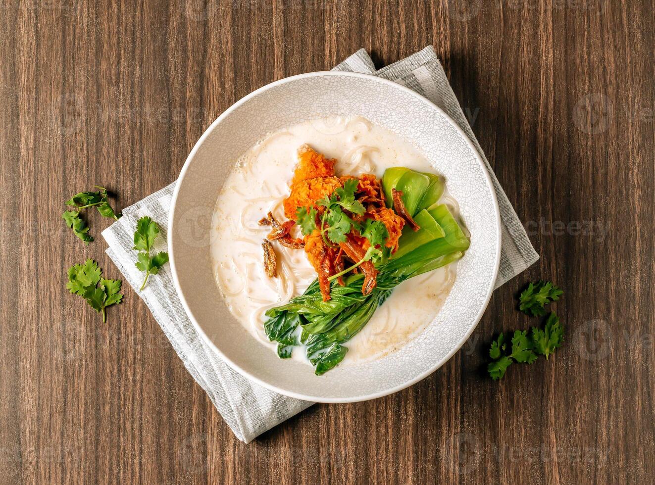 chinês salmão macarrão sopa dentro uma branco tigela sobre rústico Sombrio de madeira fundo com cópia de espaço topo Visão foto