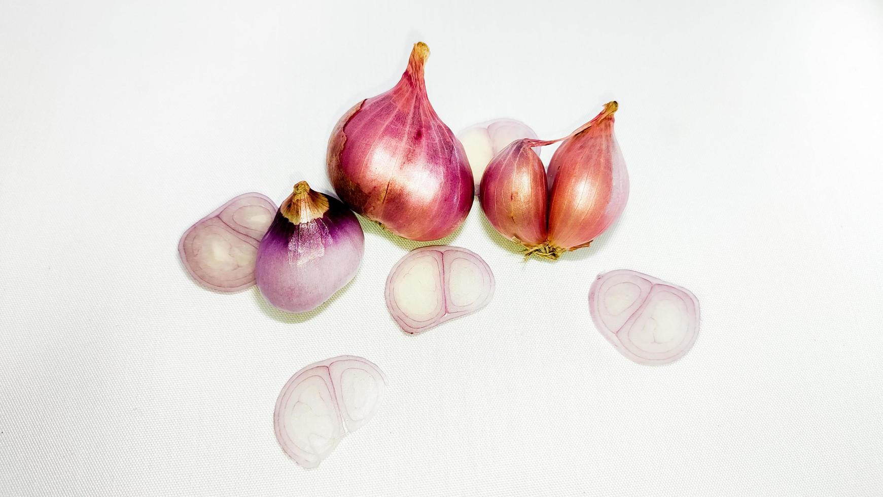 cebola vermelha inteira com fatias cortadas isoladas em um fundo branco foto