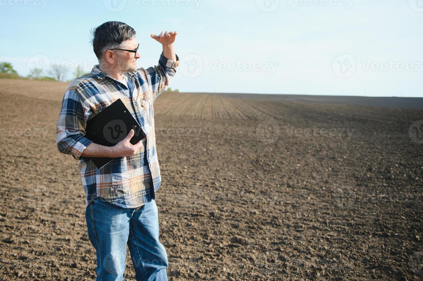 uma agricultor trabalho dentro uma campo semeado dentro Primavera. a agrônomo anda em a terra, avaliando uma arado campo dentro outono. agricultura. inteligente agricultura tecnologias. foto