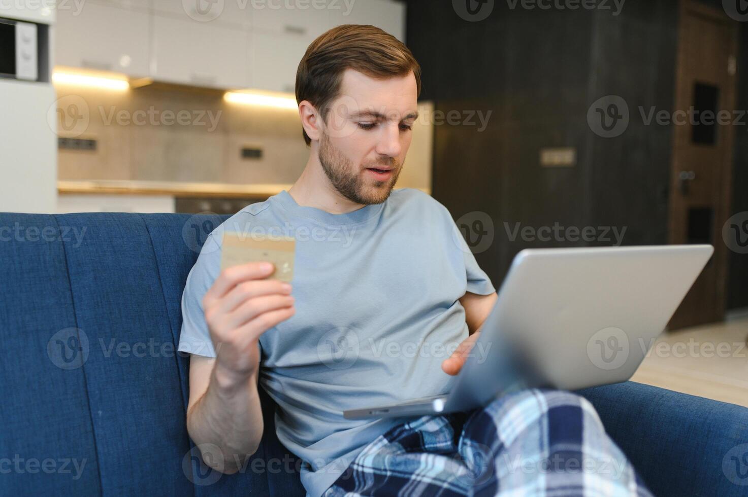 homem sorridente durante as compras on-line em casa foto