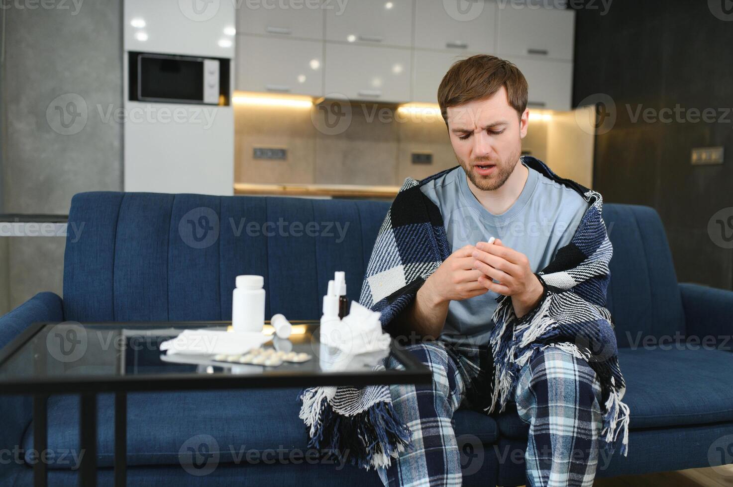 doente triste homem senta em sofá às casa sofre a partir de escorrendo nariz gripe doença coronavírus pandemia cobiçado epidemia espirra. indisposto cara sentindo-me mau febre vírus doença sintomas interior foto