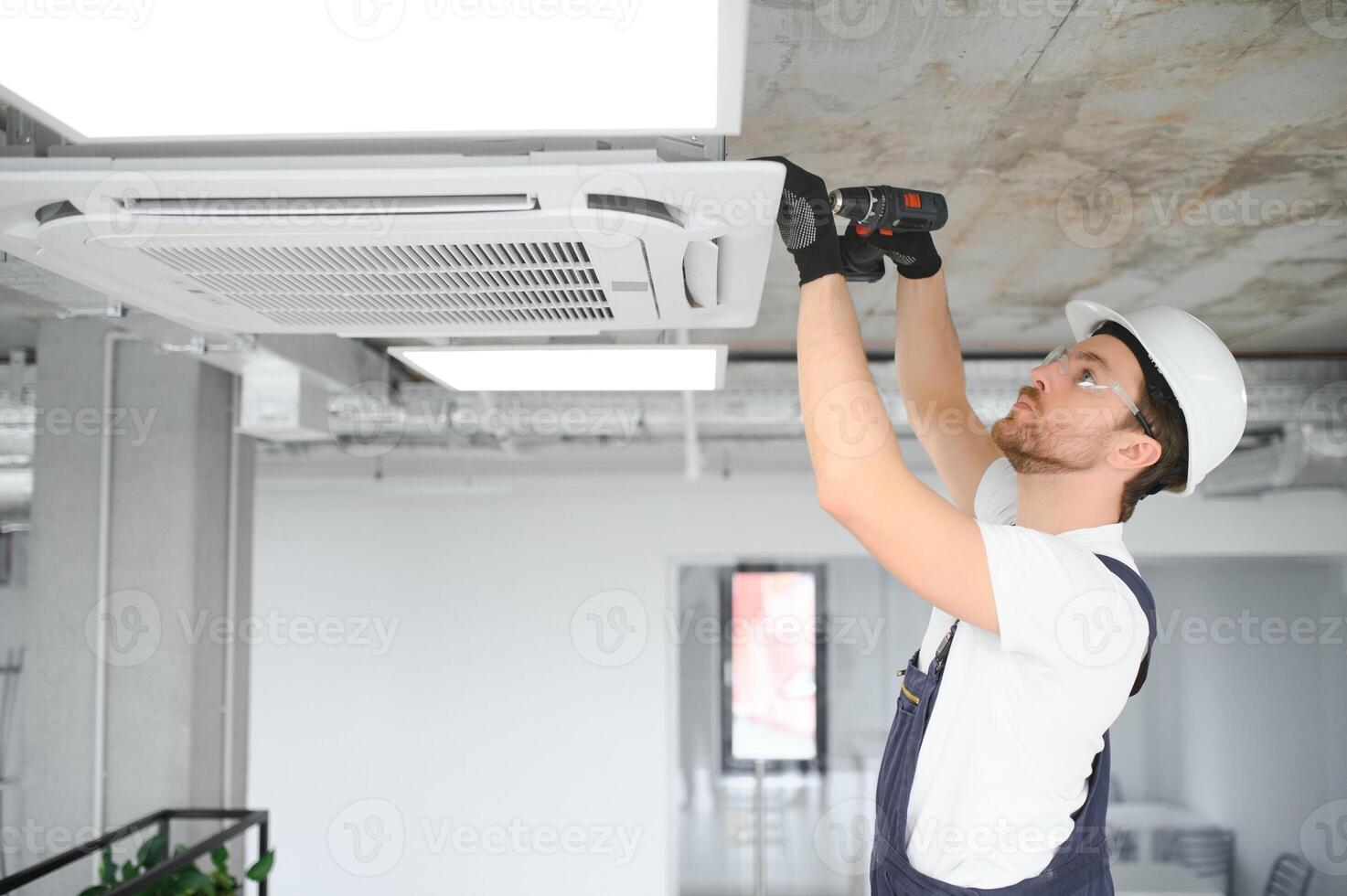 bonito jovem homem eletricista instalando ar condicionamento. foto