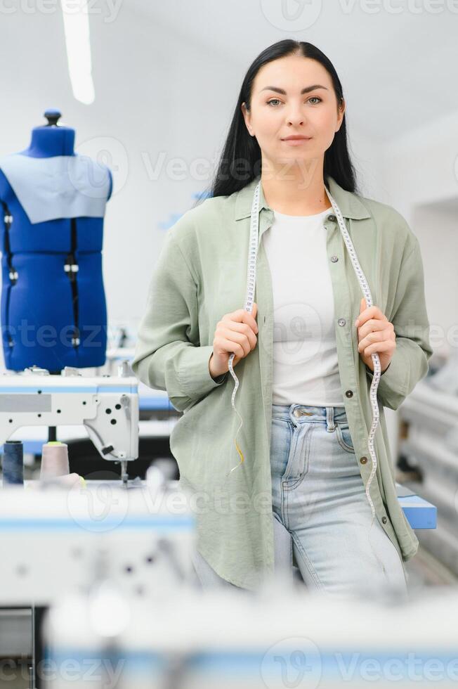 jovem mulher trabalhando Como costureira dentro roupas fábrica. foto