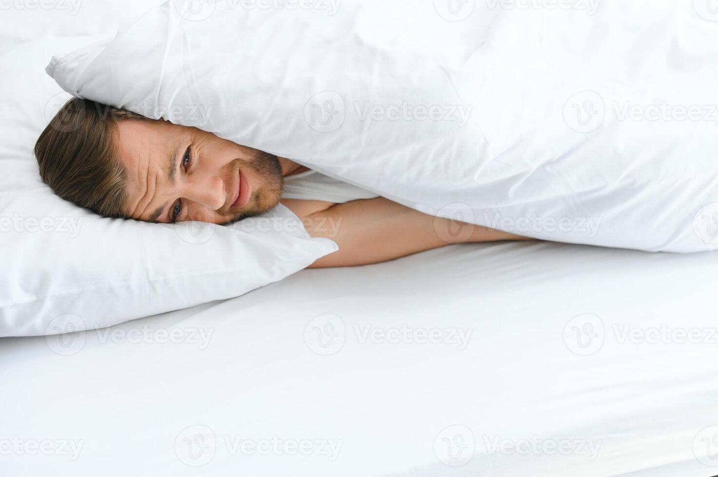 jovem homem dentro cama , tentando para dormir foto
