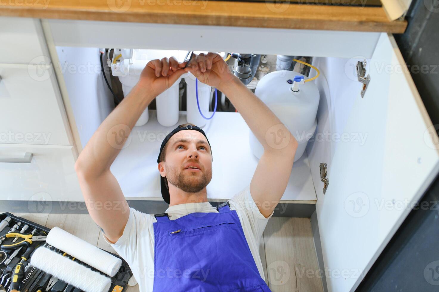 encanador trabalhando mudança cartucho filtro para água dentro cozinha. conceito filtração sistema. foto