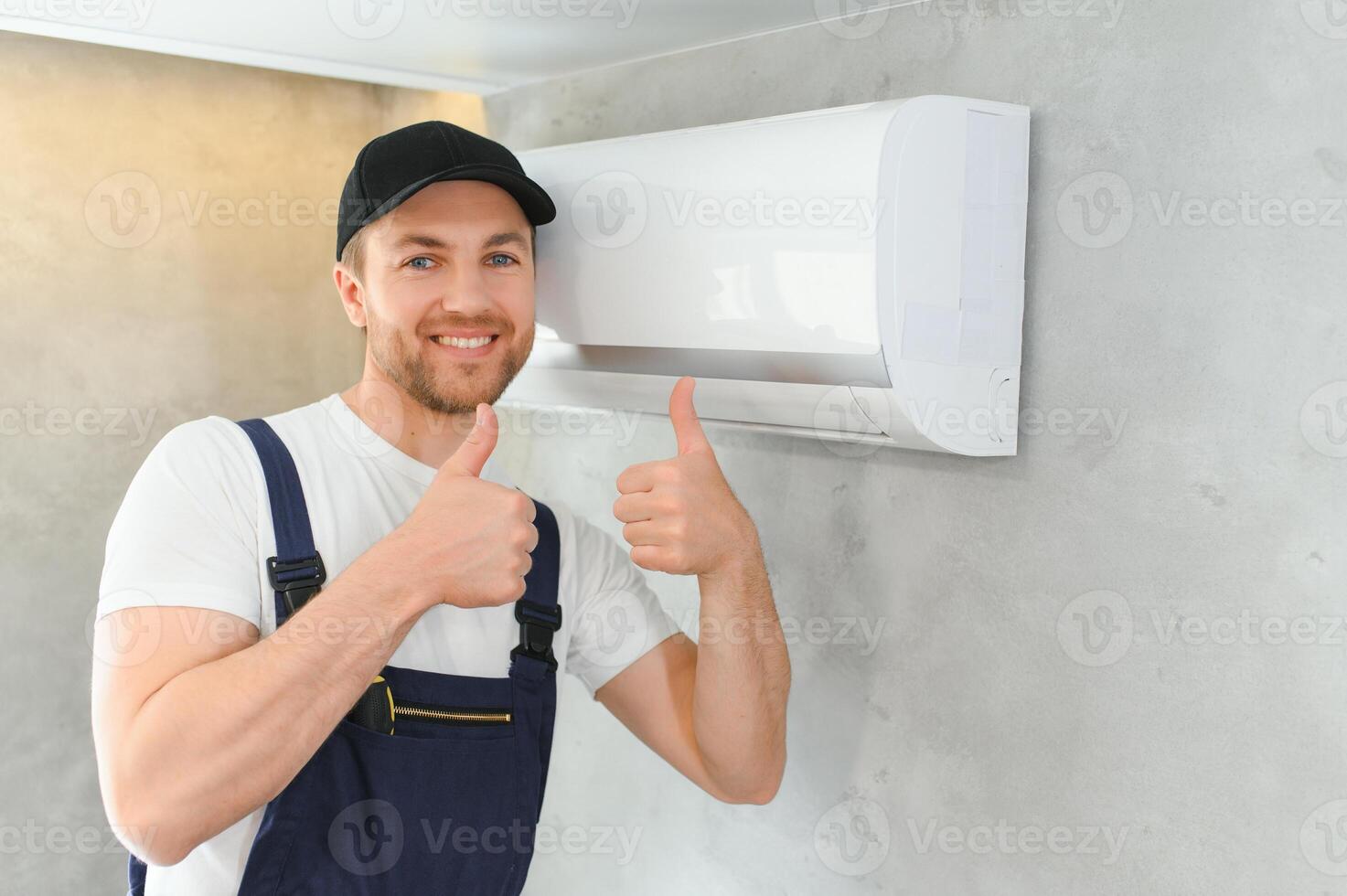 sorridente jovem masculino eletricista reparar condicionador dentro cliente lar. homem mecânico ou reparador consertar filtros dentro ar condição dispositivo às cliente casa foto