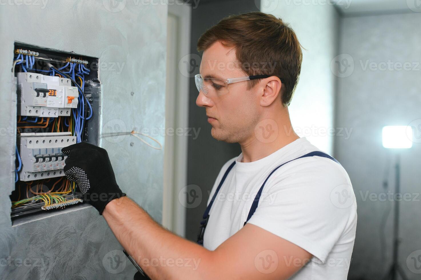 eletricista trabalhador às trabalhos em a elétrico painel foto