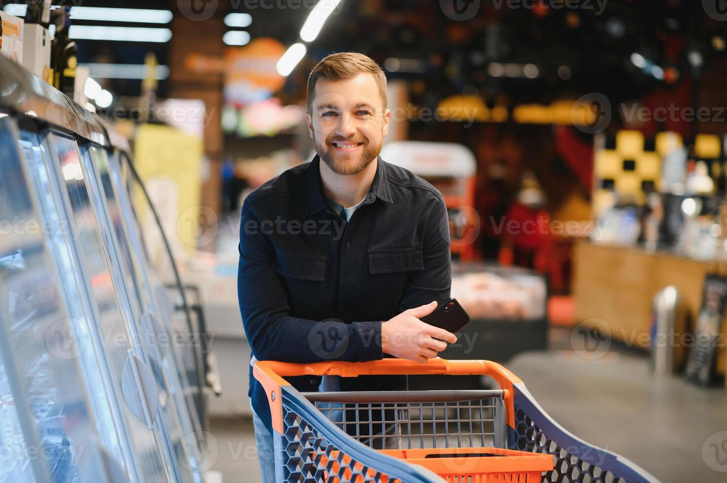 jovem homem comprando mercearias às a supermercado. de outros clientes dentro fundo. consumismo conceito. foto