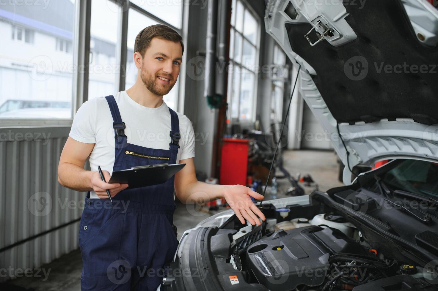 carro serviço, reparar, manutenção e pessoas conceito - feliz sorridente auto mecânico homem ou ferreiro com prancheta às oficina foto