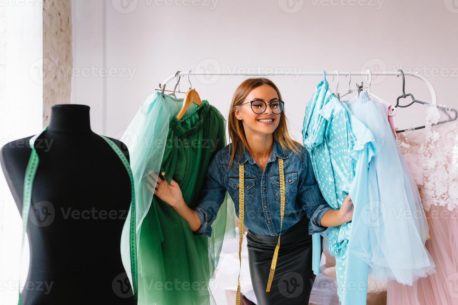 atraente fêmea moda desenhador é trabalhando dentro dela oficina. à moda mulher dentro processo do criando Novo roupas coleção. foto