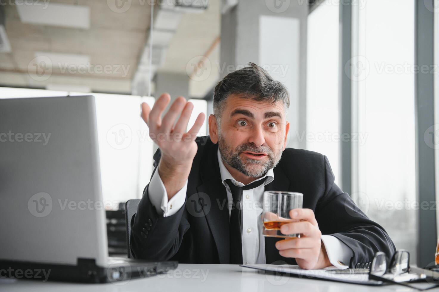 velho masculino empregado bebendo álcool às local de trabalho foto