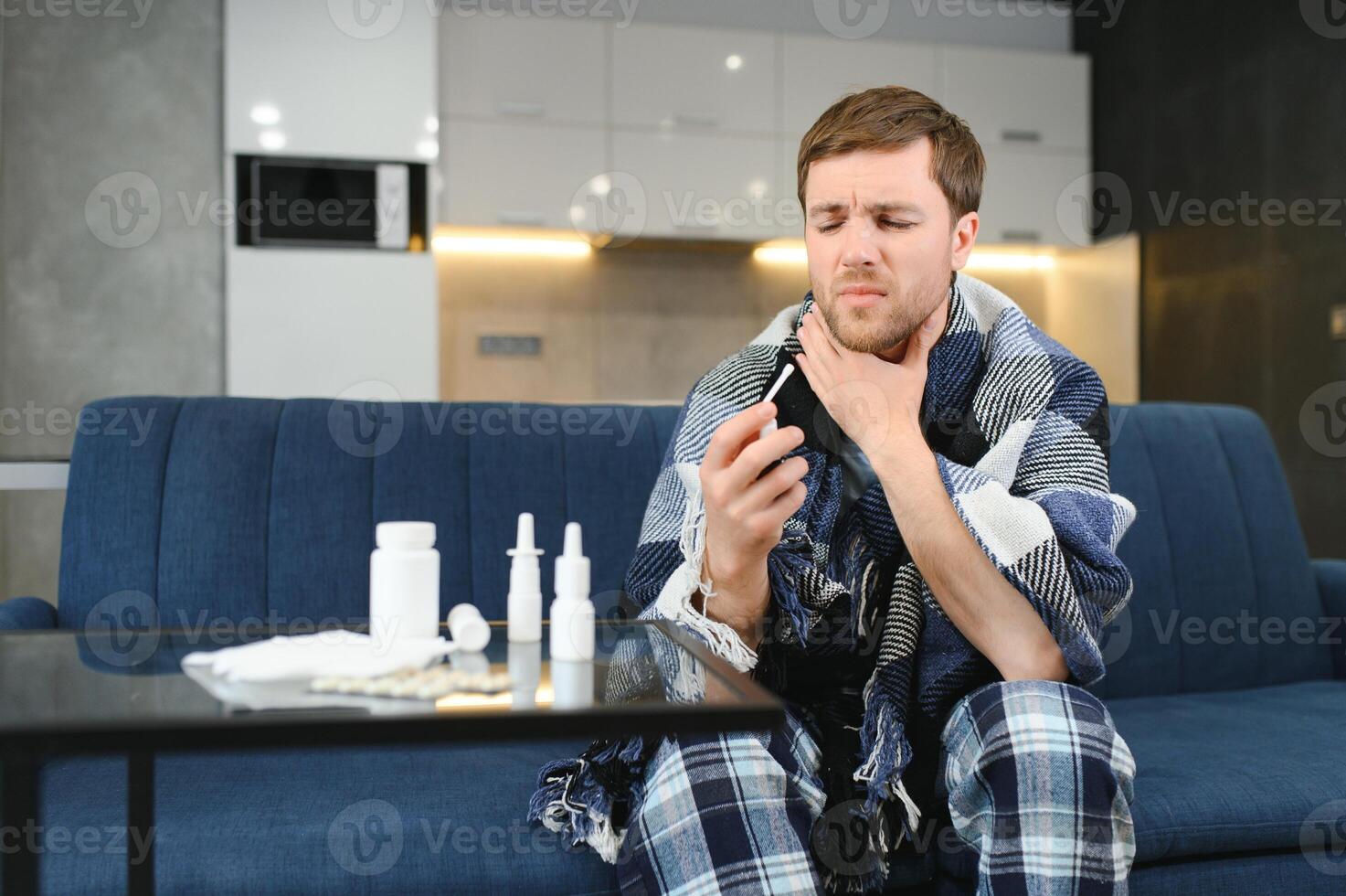 pessoas e saúde problema conceito - infeliz doente homem pulverização dele garganta com oral spray dentro cama às casa foto