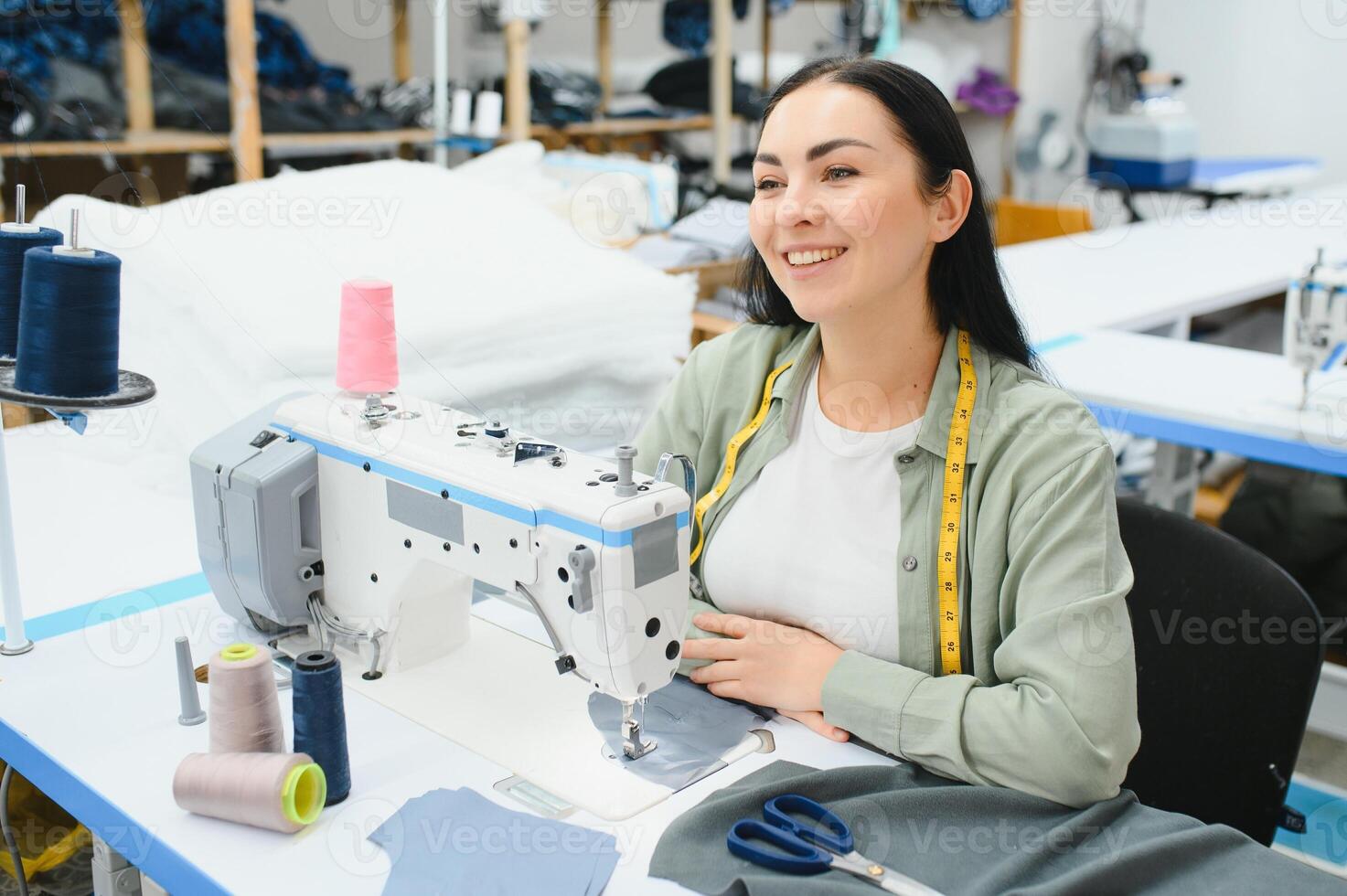 retrato do uma lindo costureira carregando uma fita a medida e trabalhando dentro uma têxtil fábrica foto