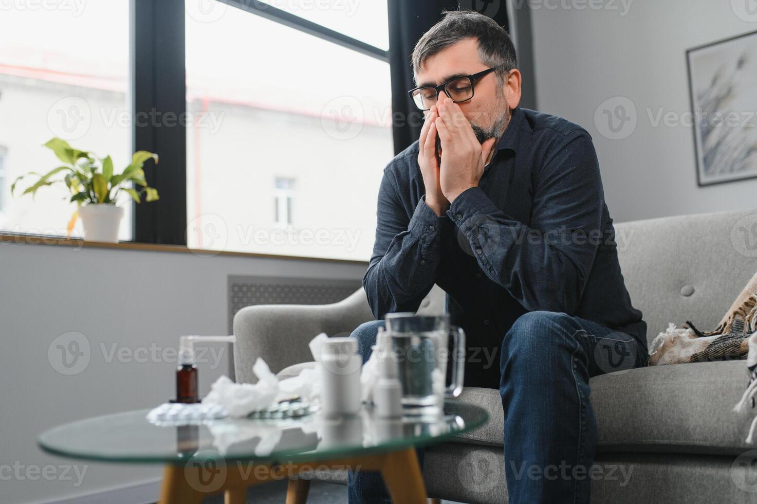 meio era homem sentindo-me doente com frio e febre às lar, eu vou com gripe doença sentado em a sofá foto