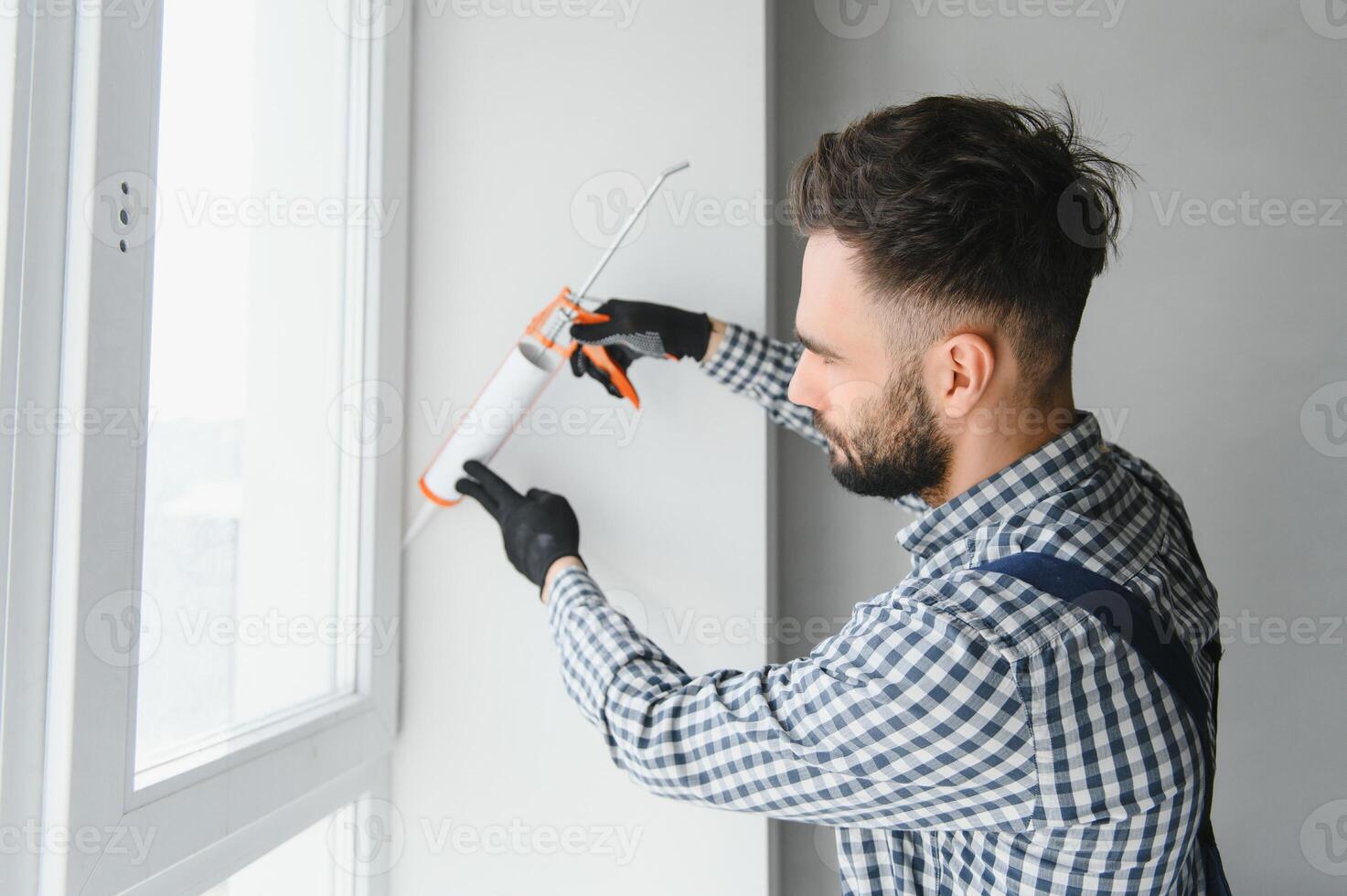 construção trabalhadores instalar portas - janelas e usar silício e selante. foto