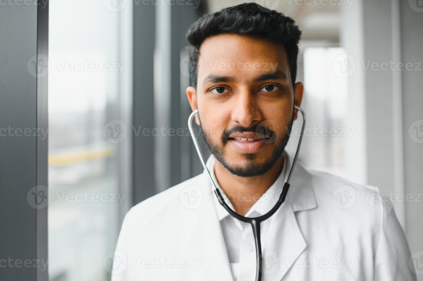 medicamento, cuidados de saúde e pessoas conceito - feliz masculino médico com estetoscópio e prancheta às clínica foto