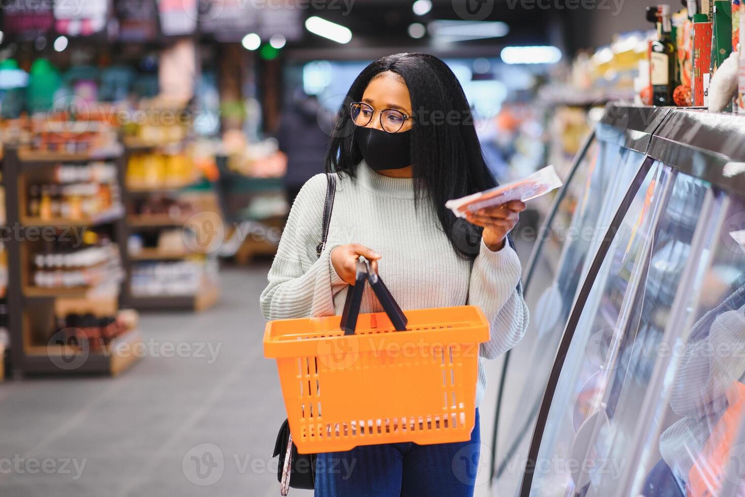 africano mulher vestindo descartável médico mascarar. compras dentro supermercado durante coronavírus pandemia surto. epidemia Tempo foto