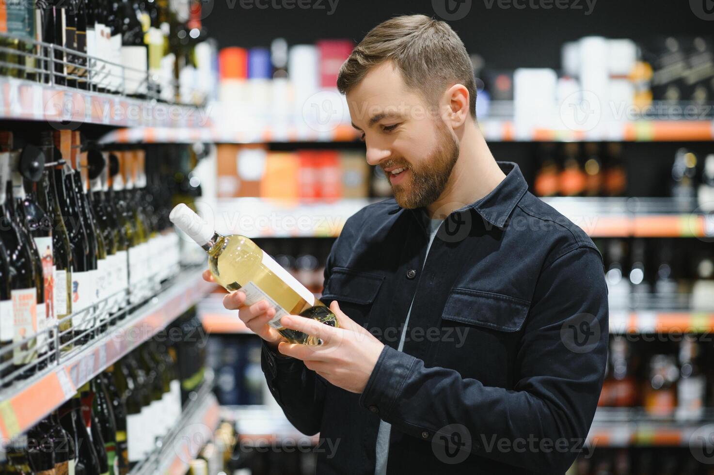 homem dentro uma supermercado escolhendo uma vinho foto