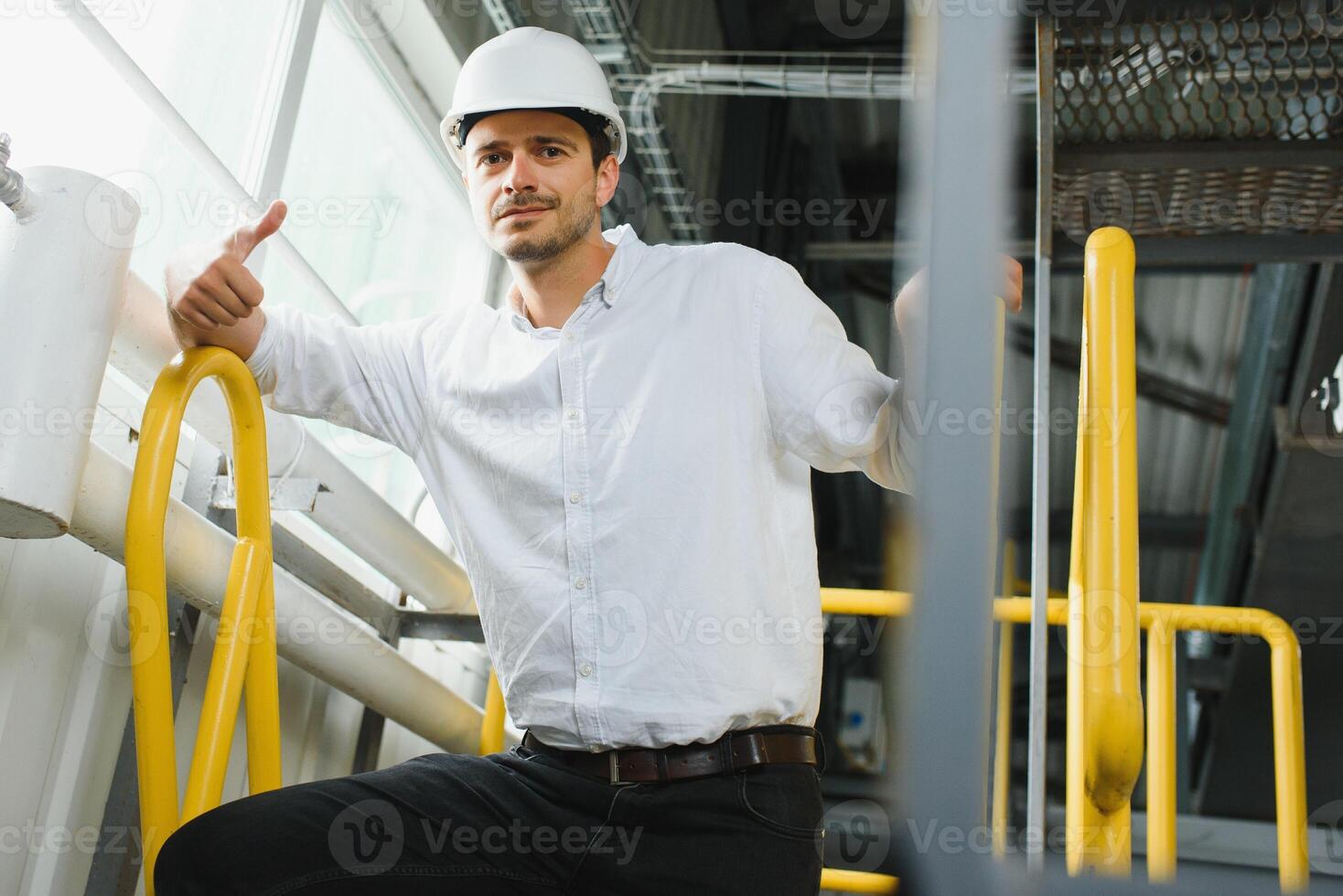 feliz masculino industrial técnico dentro uma fábrica foto