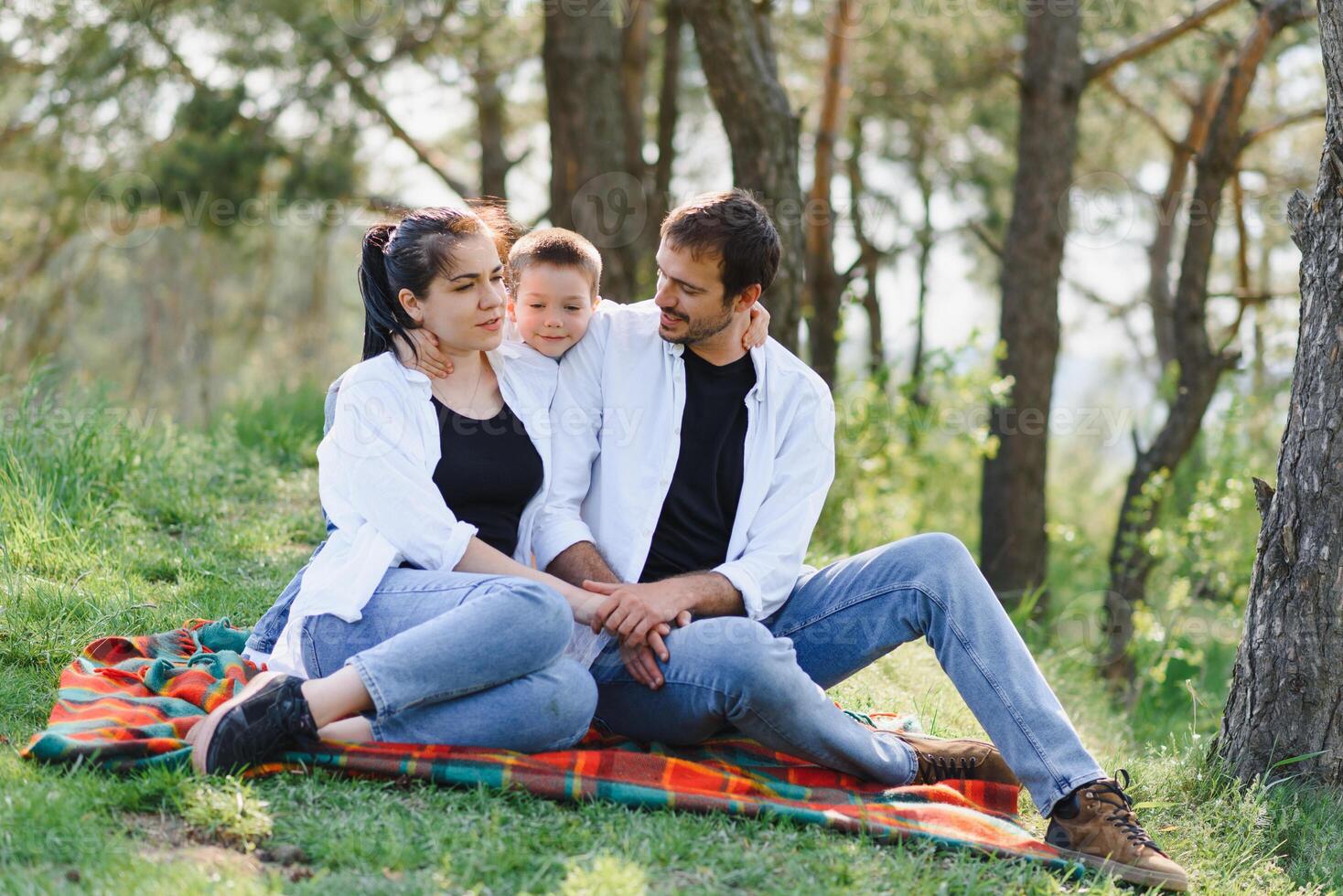 família tendo uma ótimo Tempo dentro a parque. pai abraços filho. feliz família em natureza foto