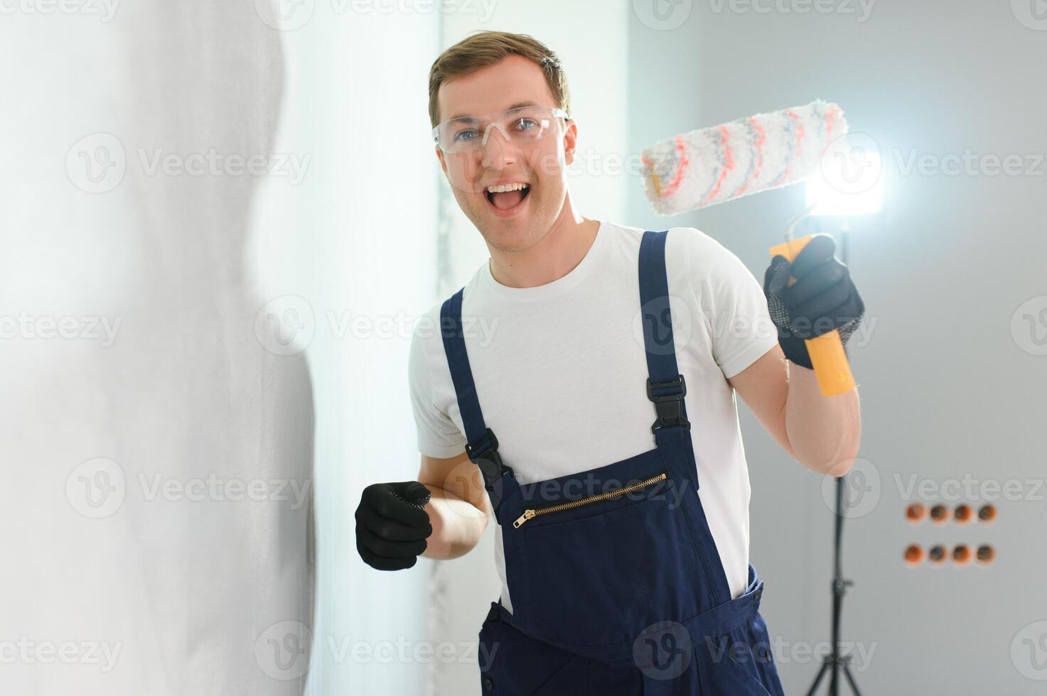 jovem trabalhador pintando parede no quarto foto