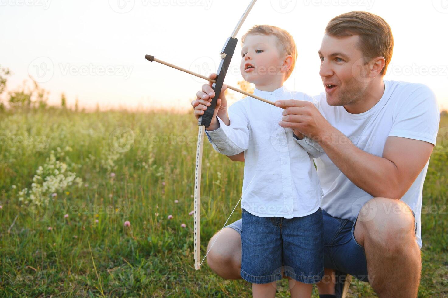 uma pai ensino dele filho quão para tiro arco. foto